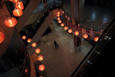 High angle view of silhouette person walking in illuminated building