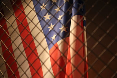 Full frame shot of american flag seen through fence