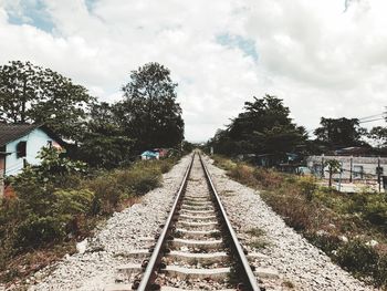 Railroad tracks amidst trees against sky