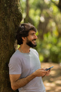 Young man at park on a beautiful sunny day with mobile phone.  working  leisure. green and nature 