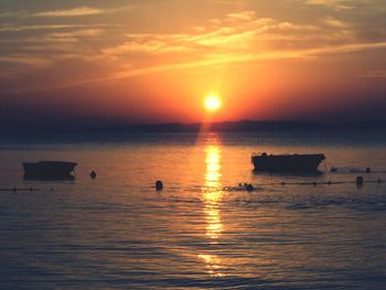 Silhouette boats on sea against sky during sunset