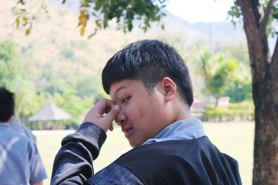 Portrait of young man standing at park