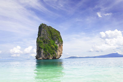 Rock formation in sea against sky