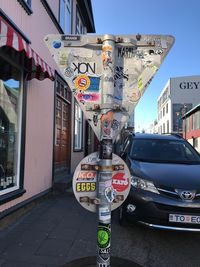 Close-up of road sign against sky in city