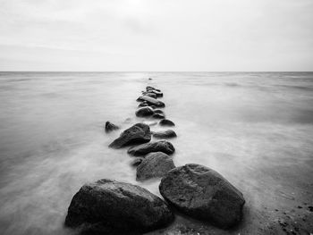 Rocks in sea against sky