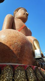 Low angle view of statue against temple against clear sky