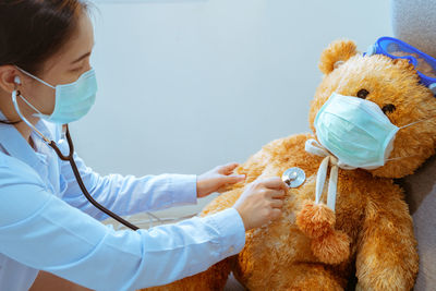 Side view of doctor examining stuffed toy