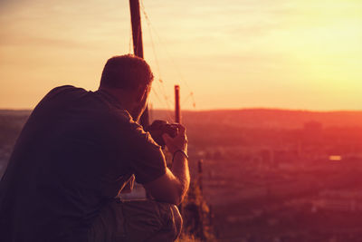 Rear view of man using camera