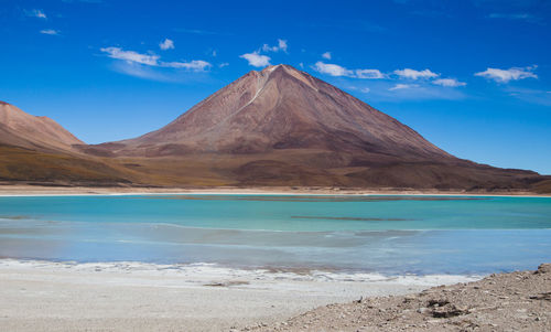 Scenic view of lake and mountains against blue sky