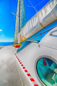 Sailboat sailing in sea against blue sky