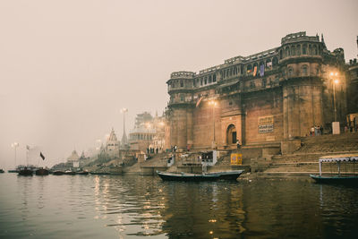 Boats in river with buildings in background