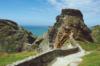 Historic wall and rock formation against sky