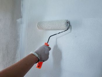 Close-up of person hand holding painting wall