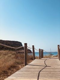 Boardwalk against clear blue sky