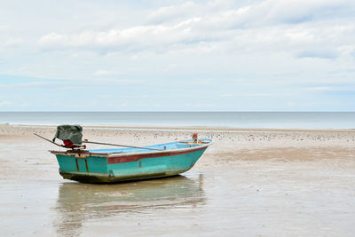 Boat moored on sea against sky