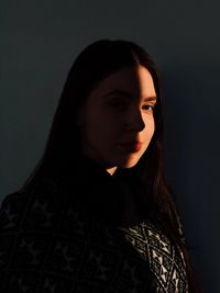 Portrait of young woman against gray background