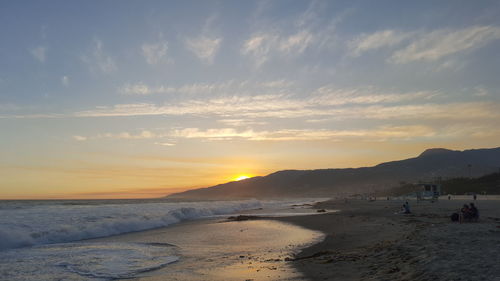 Scenic view of beach against sky during sunset