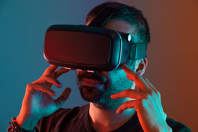 Young man in vr glasses close up portrait virtual reality in color neon light,  video gaming