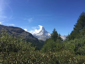 Scenic view of mountains against blue sky