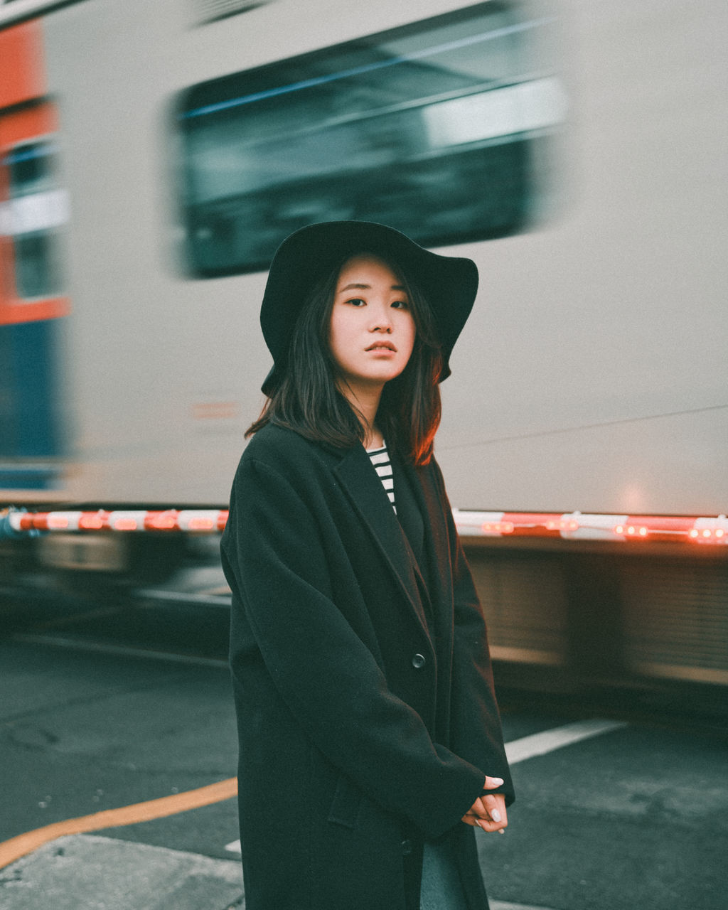 transportation, one person, mode of transportation, women, adult, clothing, rail transportation, public transportation, young adult, motion, city, travel, train, architecture, person, standing, blurred motion, lifestyles, city life, female, portrait, vehicle, journey, railroad station, speed, black, smiling, commuter, emotion, human face, hat, railroad station platform, outdoors, subway train, waist up, happiness, on the move, looking