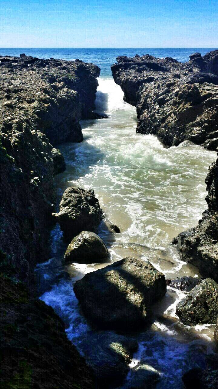 sea, water, horizon over water, rock - object, scenics, tranquil scene, beauty in nature, tranquility, rock formation, nature, rock, blue, idyllic, beach, shore, sky, coastline, cliff, outdoors, clear sky