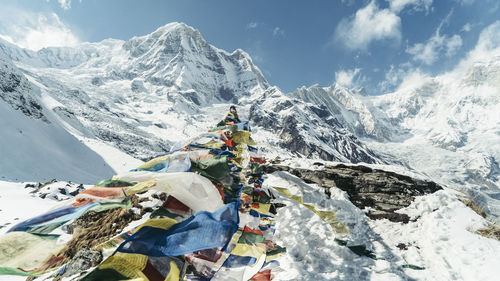 Prayer flags on machapuchare snowcapped mountains against sky