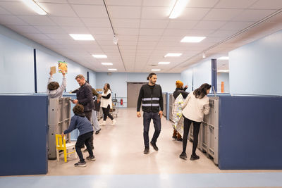 Customers and workers with crates at recycling center