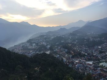 High angle view of townscape by mountains against sky