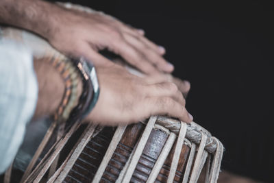 Close-up of man holding hands over black background