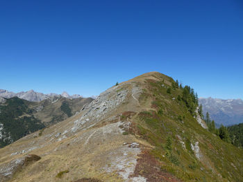 Scenic view of mountains against clear blue sky