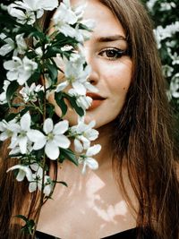 Close-up portrait of woman with red flowers