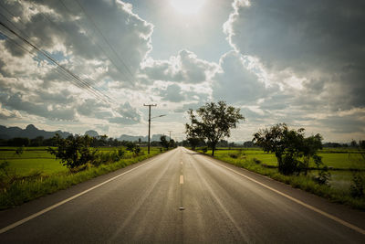 Road amidst trees against sky