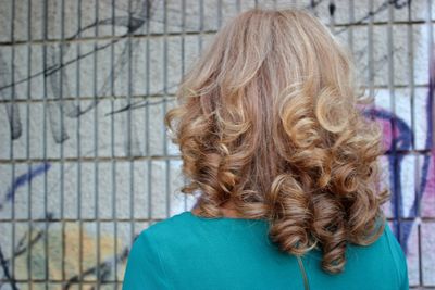 Rear view of woman with brown hair against fence