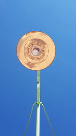 Directly below shot of lighting equipment against clear blue sky