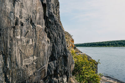 Rock formation in sea against sky