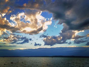 Scenic view of sea against dramatic sky during sunset