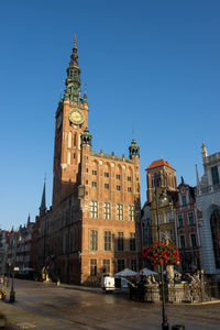 Low angle view of buildings against clear blue sky
