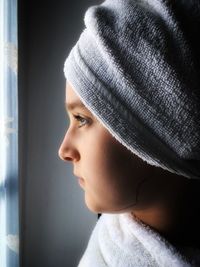 Close-up of girl wearing towel while looking through window