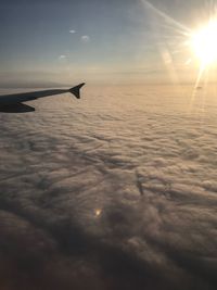 Airplane flying over sea against sky during sunset