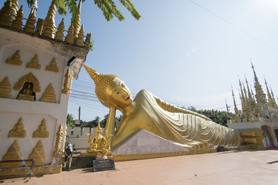 Statue against temple building against sky