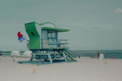 Lifeguard hut on beach against sky