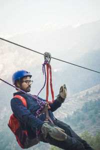 Young man hanging on zip-line