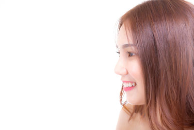 Portrait of a smiling young woman against white background