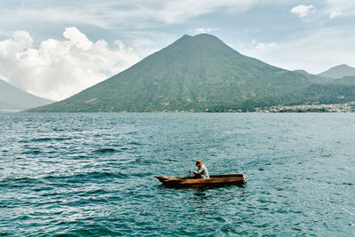 Man surfing in sea against sky