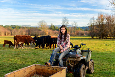 Side view of woman sitting on atv on field