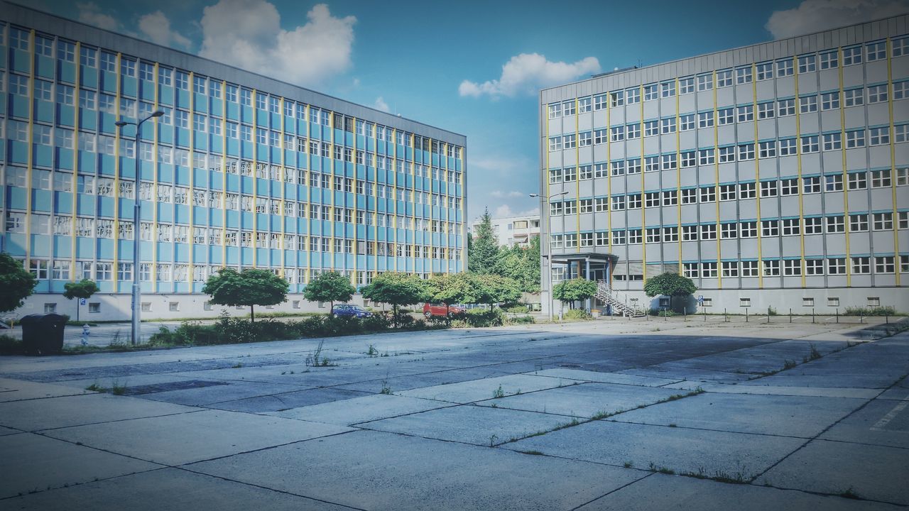 building exterior, architecture, built structure, city, sky, building, street, modern, day, cloud - sky, glass - material, office building, outdoors, window, sunlight, blue, sidewalk, wall - building feature, no people, road