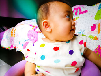 Close-up of cute baby boy on bed at home