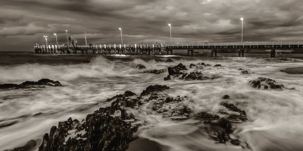 Scenic view of sea against cloudy sky at night