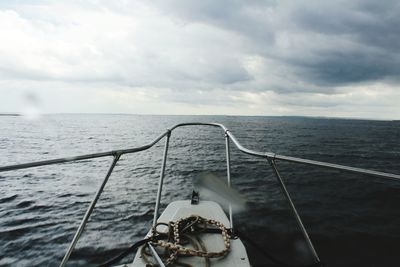 Close-up of boat sailing on sea against sky