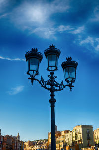 Low angle view of street light against blue sky